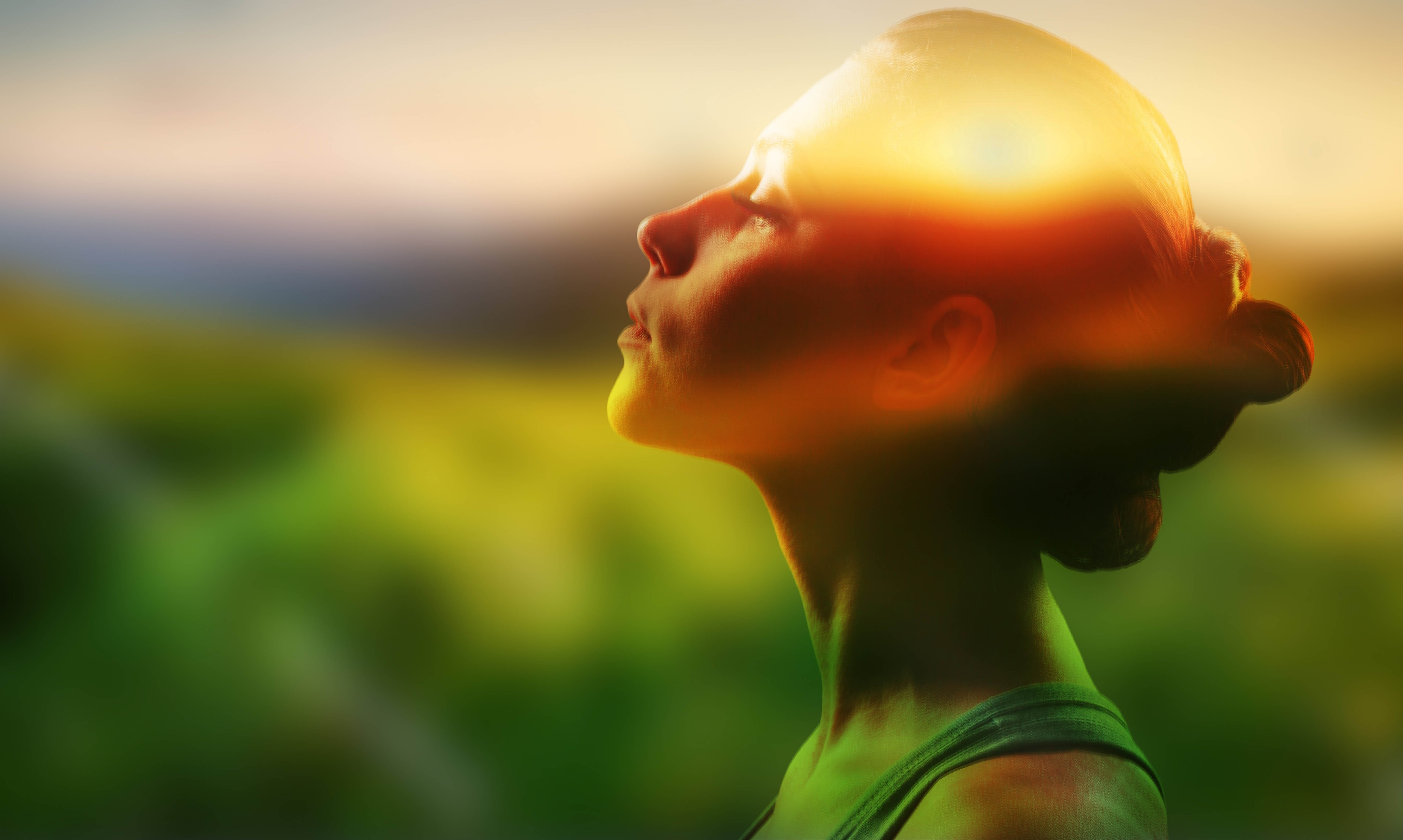 Woman with her eyes closed and face tilted towards the sun, showing her gratitude for life